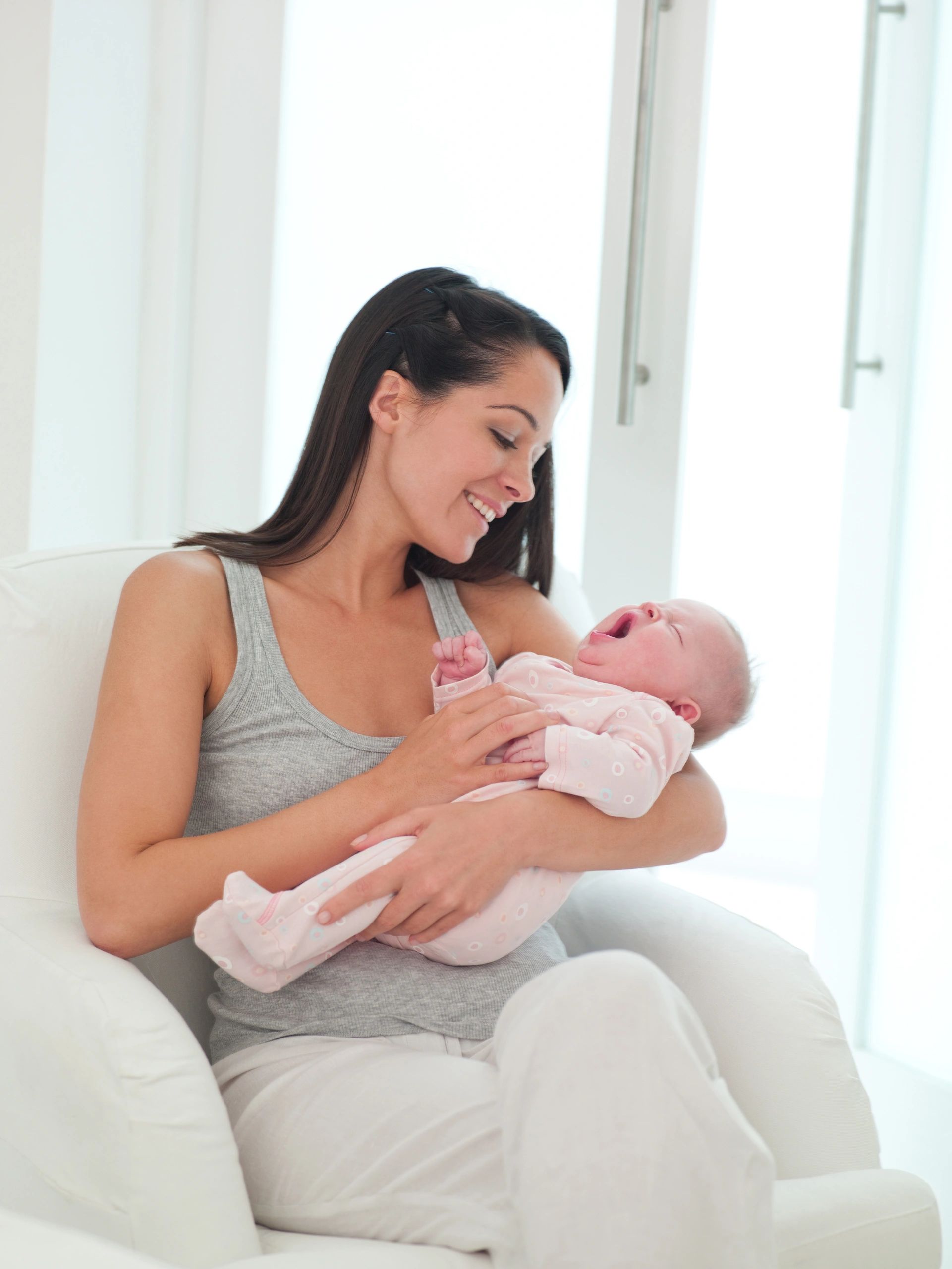 Smiling mother holding sleeping baby