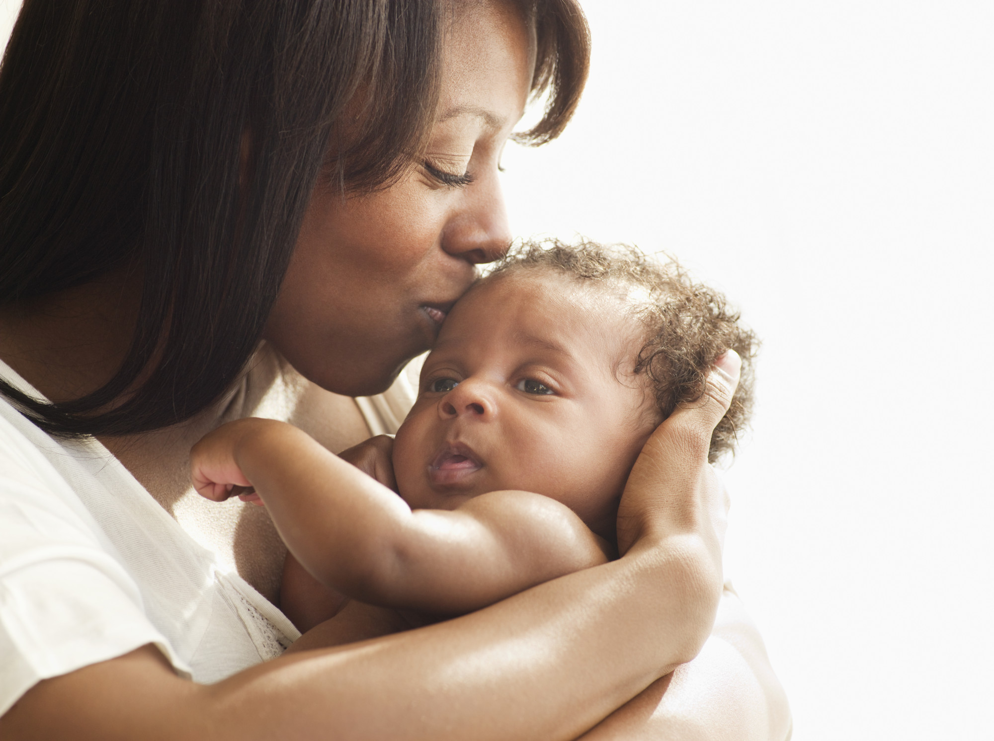 Mother kissing and hugging baby