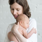 Smiling mother holding her newborn baby